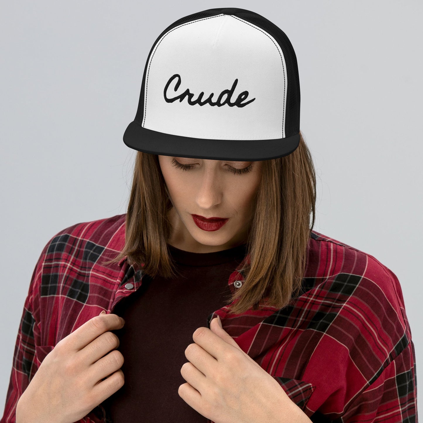Woman wearing Crude Script Trucker Hat with bold lettering and mesh back panel.