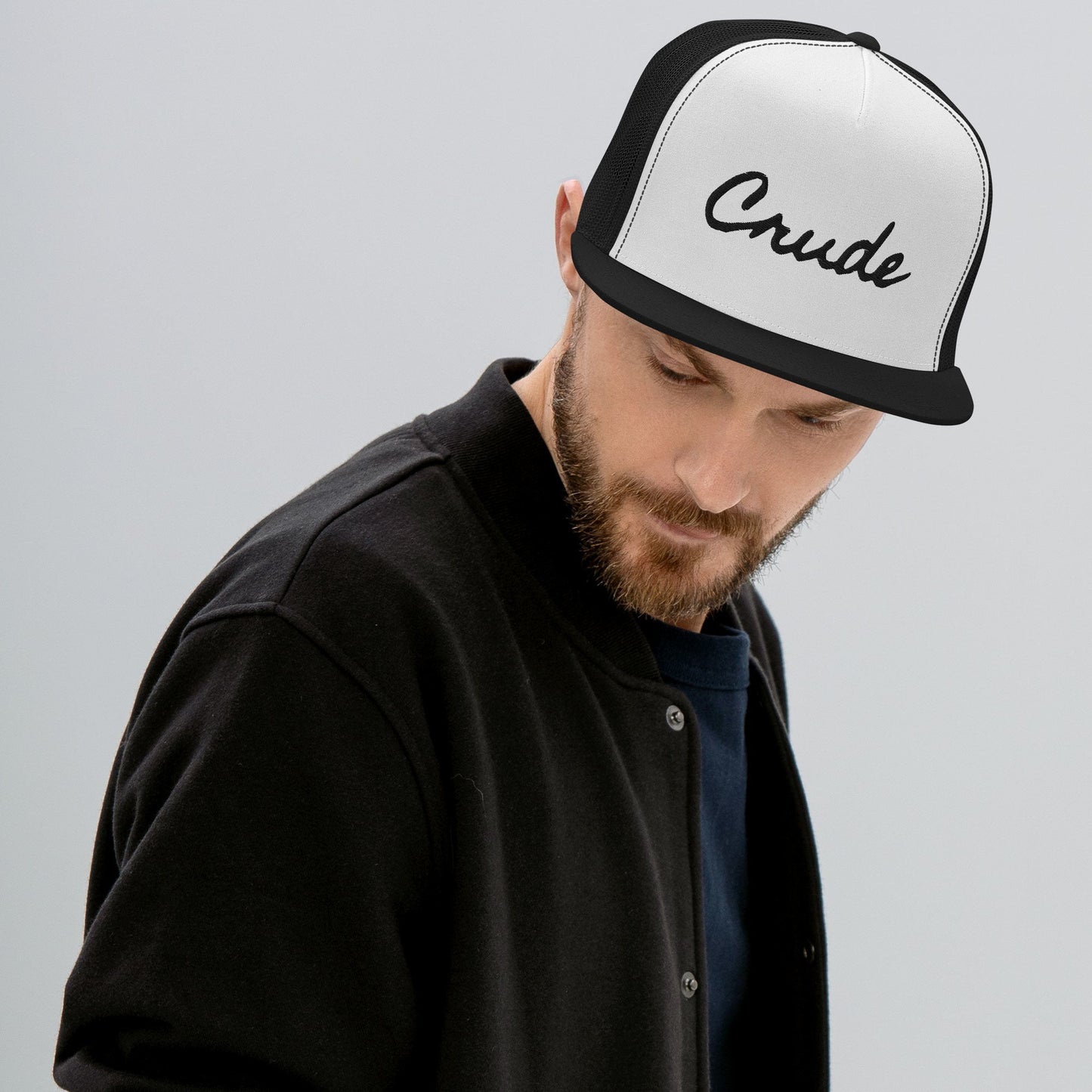 Man wearing Crude Script Trucker Hat with bold lettering and mesh back panel.