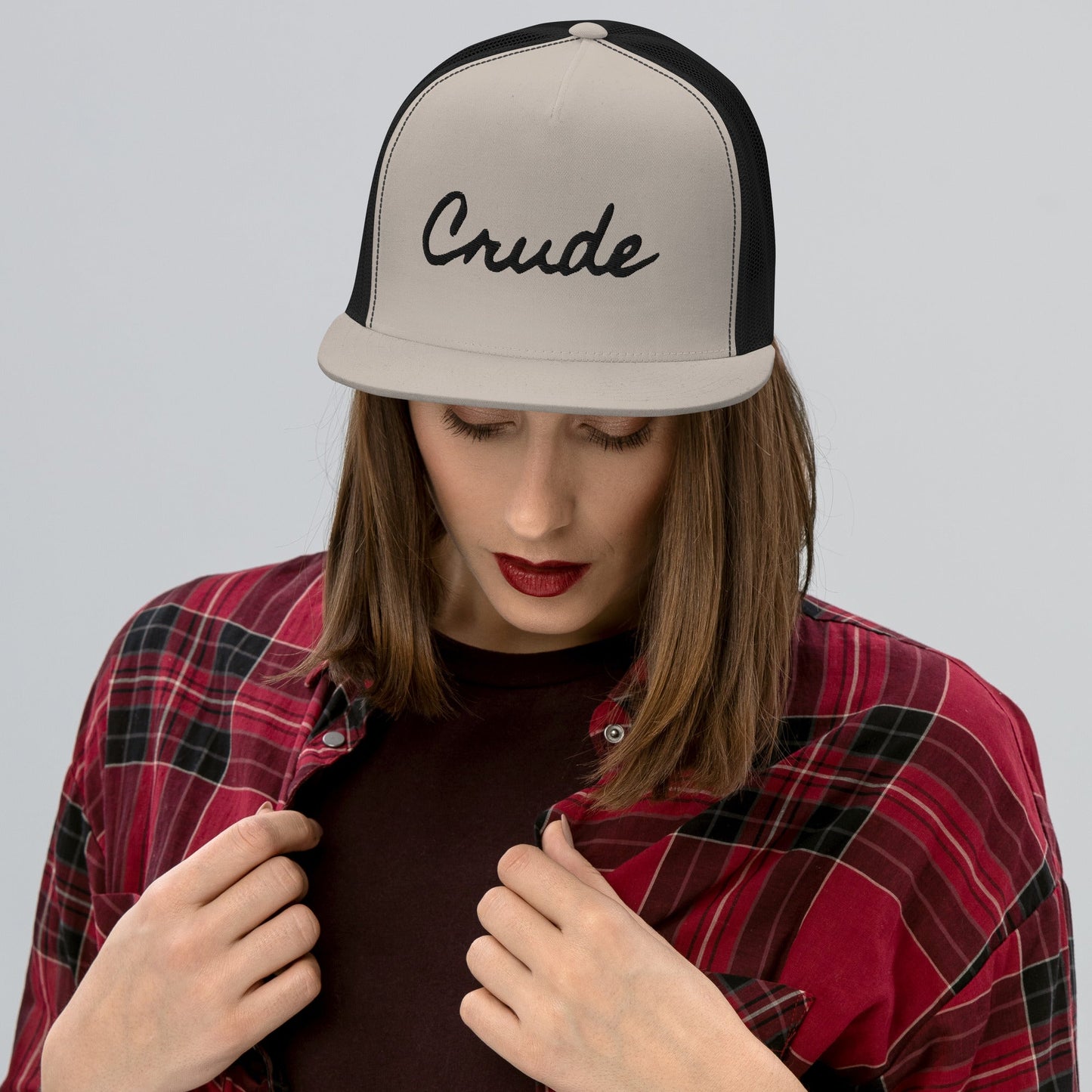 Woman wearing Crude Script Trucker Hat with bold lettering and mesh back panel.