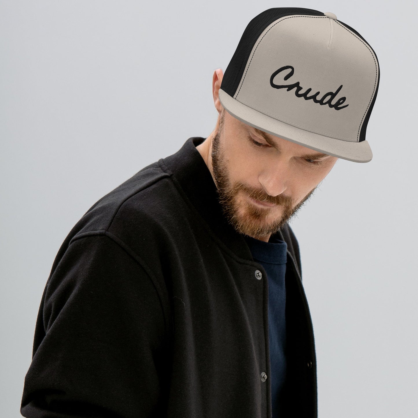 Man wearing Crude Script Trucker Hat with bold lettering and mesh back panel.