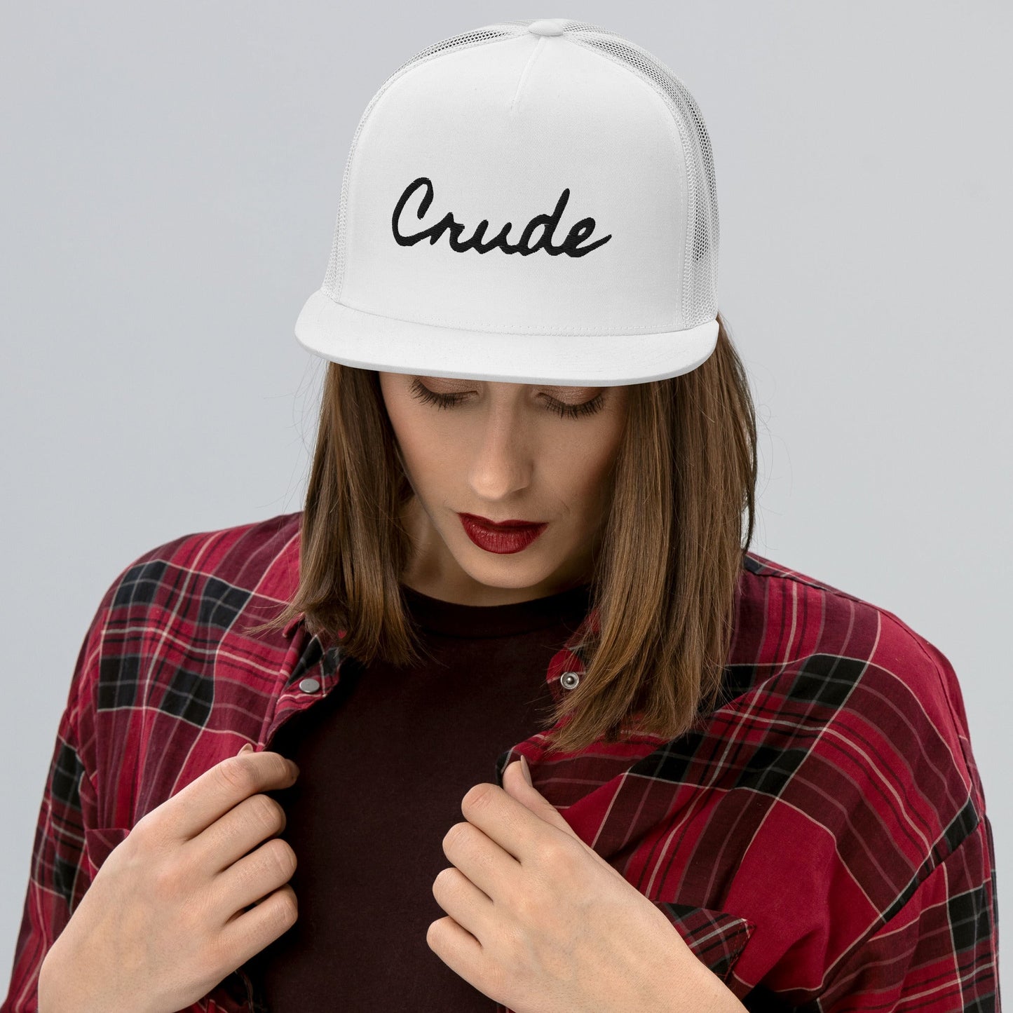 Woman wearing Crude Script Trucker Hat with bold lettering and mesh back panel.